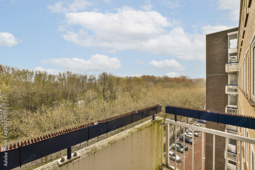 an outside area with trees and buildings in the background, taken from a window looking out to the street below