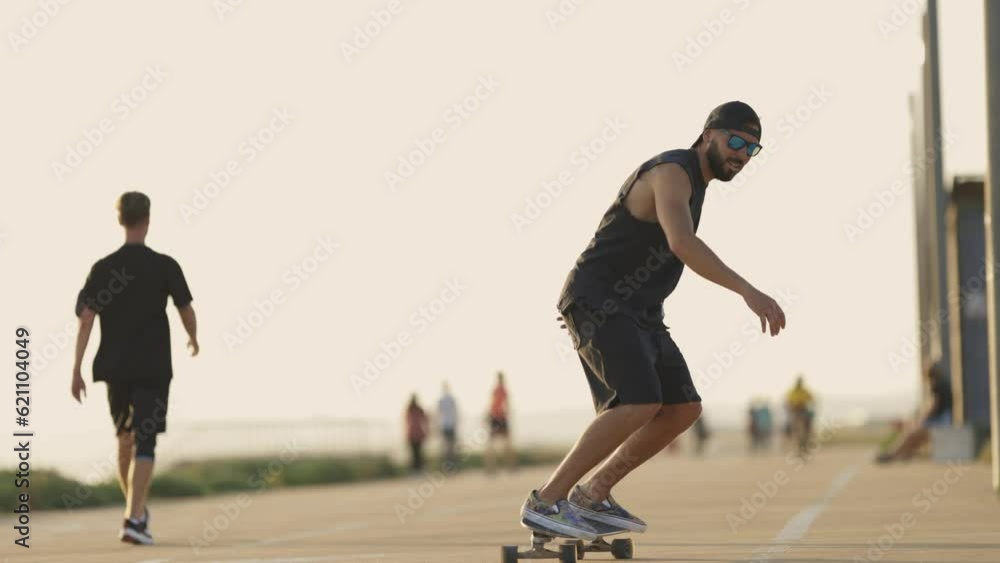 Adult attractive man skating on skateboard on the street Adult attractive man skating on skateboard on the street