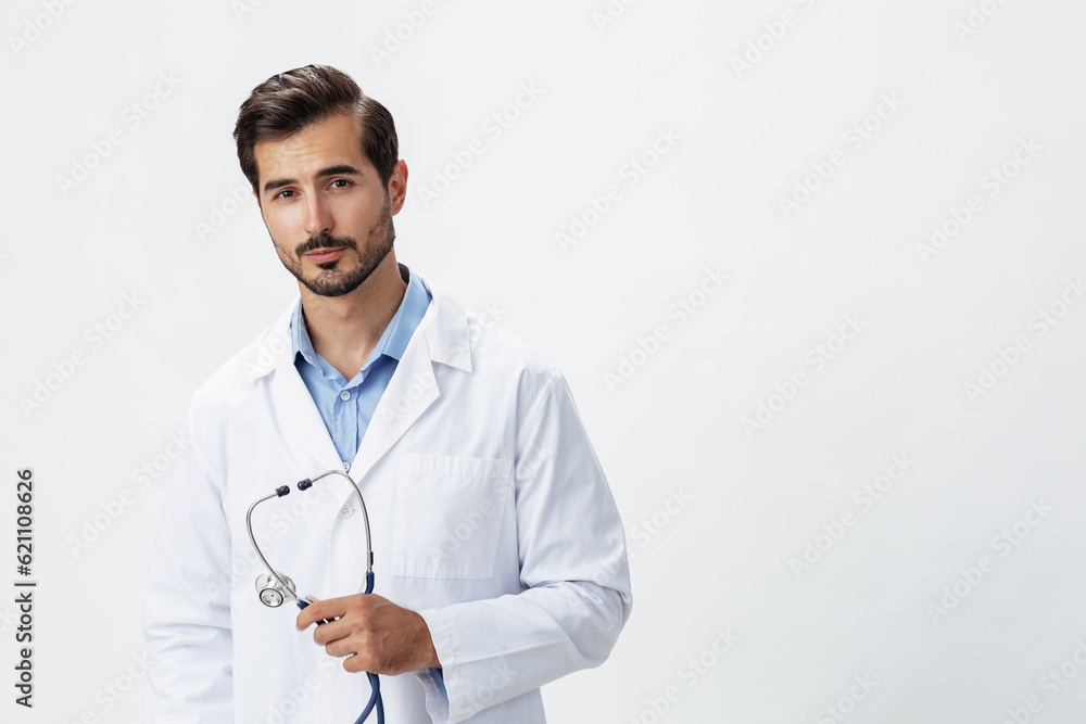A man doctor in a white coat with a stethoscope and wearing serious glasses on a white insulated background looking into the camera, copy space, space for text, health A man doctor in a white coat with a stethoscope and wearing serious glasses on a white insulated background looking into the camera, copy space, space for text, health