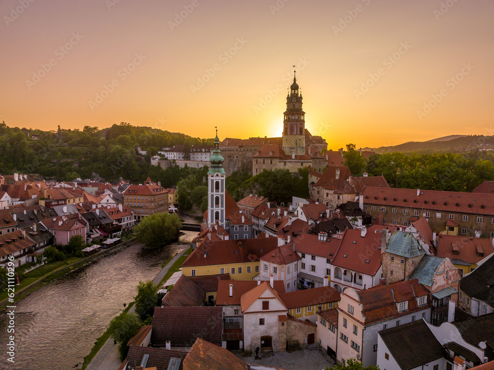 The sun setting behind Cesky Krumlov medieval hilltop castle above the Vltava river