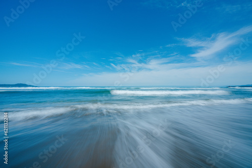 砂浜の上を流れる海の波