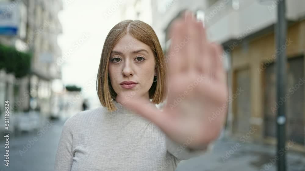 Young blonde woman doing stop gesture with hand at street Young blonde woman doing stop gesture with hand at street