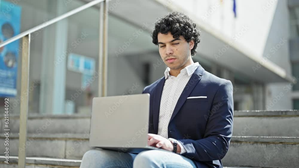Young latin man business worker using laptop sitting on floor at street Young latin man business worker using laptop sitting on floor at street