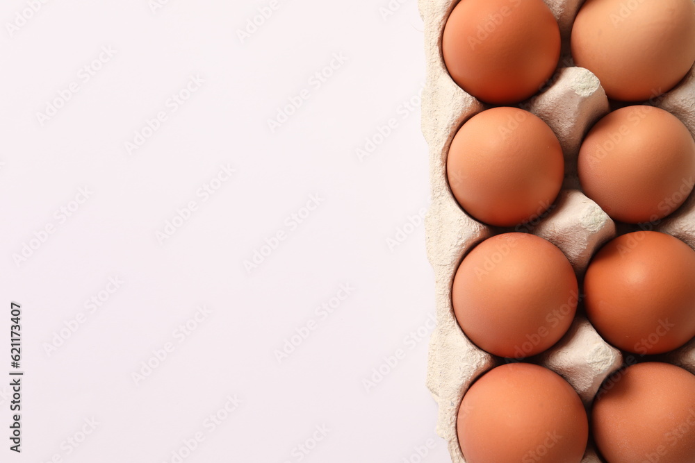 Сhicken eggs lie in a cardboard tray on a white background, top view Сhicken eggs lie in a cardboard tray on a white background, top view