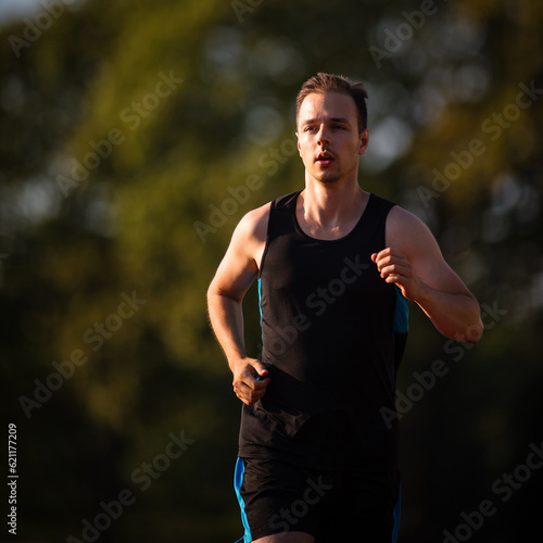 Handsome young runner jogging outdoors on a lovely summer evening
