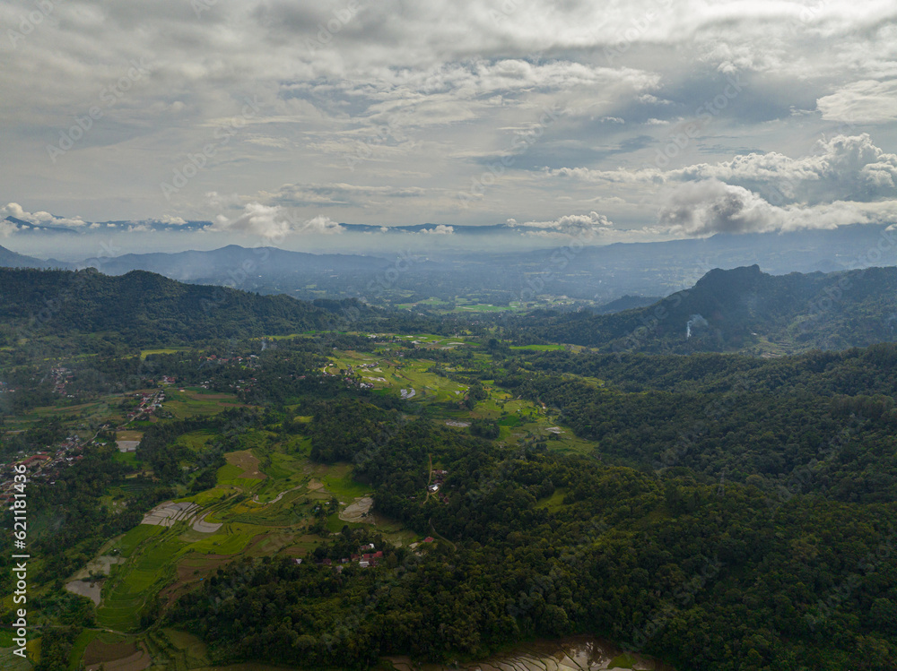 Aerial drone of mountains with green forests and agricultural land with farm plantations. Bukittinggi, Sumatra. Indonesia.