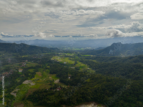 Aerial drone of mountains with green forests and agricultural land with farm plantations. Bukittinggi  Sumatra. Indonesia.