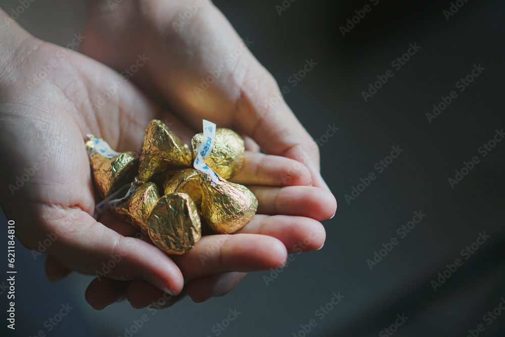 Hand holds a mini chocolate bar isolated on dark background Hand holds a mini chocolate bar isolated on dark background