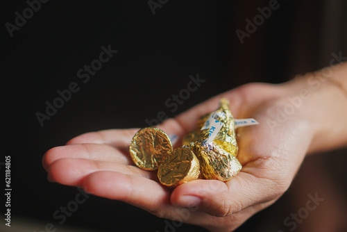 Hand holds a mini chocolate bar  isolated on dark background 
