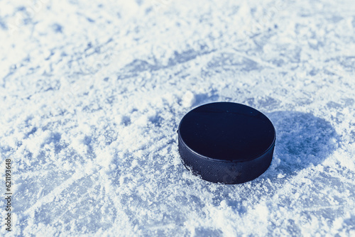 Photography hockey puck lies on the snow close-up
