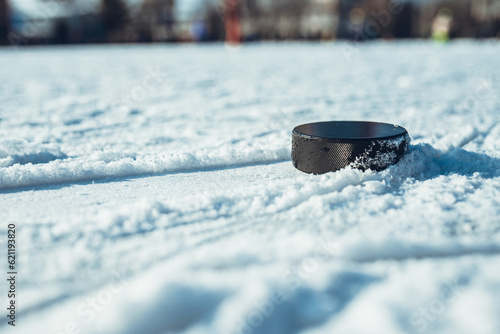 Canvas Print hockey puck lies on the snow close-up