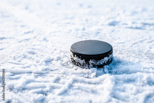 Canvas Print hockey puck lies on the snow close-up