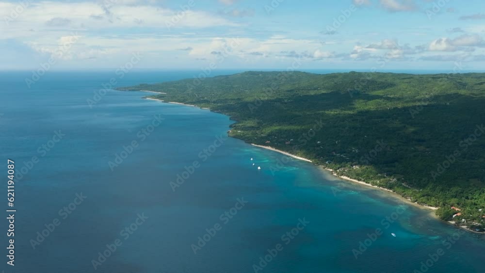 Aerial view of four boats enjoying the tropical island with a beach in the open ocean under the big clouds in the skyline. Siquijor, Philippines. Aerial view of four boats enjoying the tropical island with a beach in the open ocean under the big clouds in the skyline. Siquijor, Philippines.