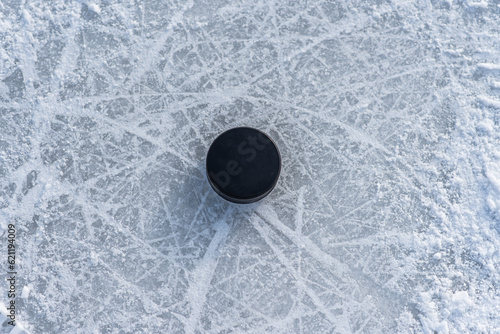 Photography hockey puck lies on the snow close-up