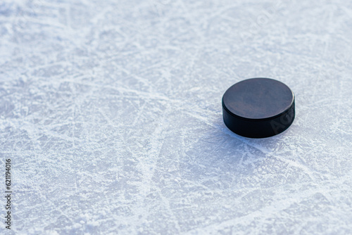 Photography hockey puck lies on the snow close-up