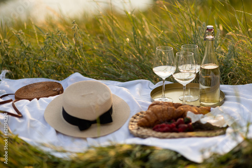 Obraz na płótnie Romantic picnic with croissants, white wine and fresh berries in the mountain at sunny summer day. w salonie