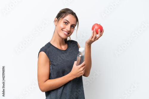 Young pretty Uruguayan woman isolated on white background with an apple and with a bottle of water