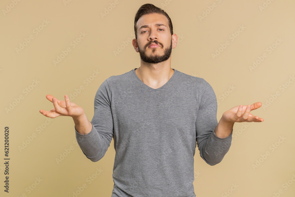 No idea, I dont know answer. Puzzled clueless uncertain lebanese handsome man raising hands in helpless gesture, embarrassed confused by difficult question. Confused one guy on beige studio background No idea, I dont know answer. Puzzled clueless uncertain lebanese handsome man raising hands in helpless gesture, embarrassed confused by difficult question. Confused one guy on beige studio background