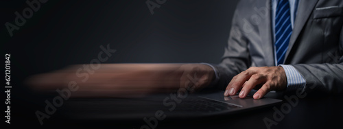 Person typing on laptop keyboard, businessman working on laptop, he is typing messages to colleagues and making financial information sheet to sum up the meeting.