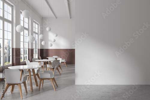 Stylish cafe interior with chairs and round table in row, window. Mock up wall