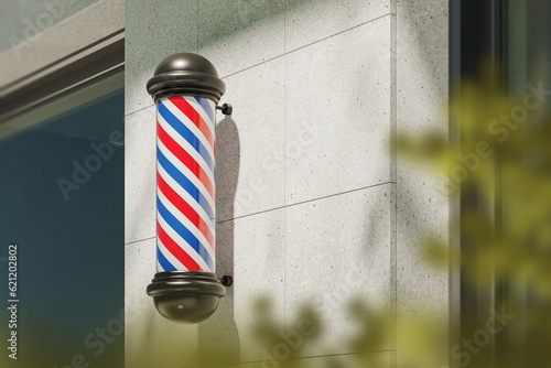 Barbershop pole mounted on grey concrete wall, city street advertising
