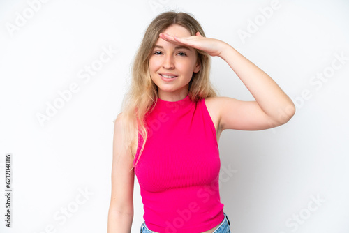 Blonde English young girl isolated on white background looking far away with hand to look something