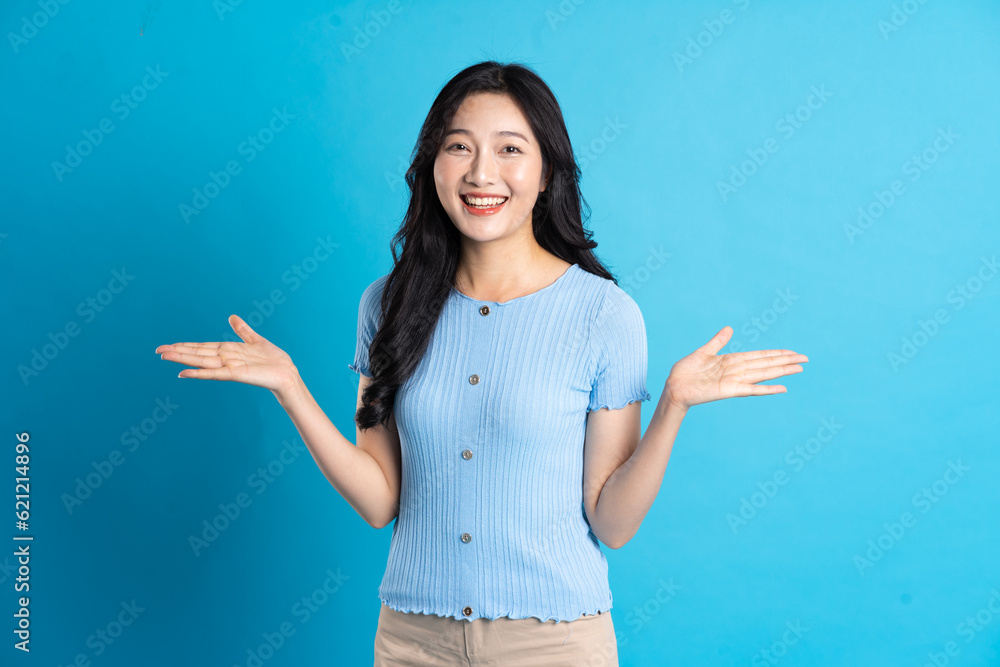 Portrait of a happy smiling asian girl posing on a blue background Portrait of a happy smiling asian girl posing on a blue background