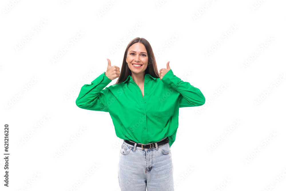 smiling cheerful young caucasian brunette lady with makeup dressed in a green shirt and jeans on a white background with copy space smiling cheerful young caucasian brunette lady with makeup dressed in a green shirt and jeans on a white background with copy space