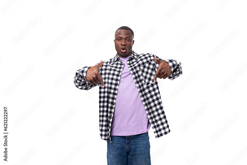 stylish young american guy with short haircut dressed casually pointing with his hand on a white background with copy space stylish young american guy with short haircut dressed casually pointing with his hand on a white background with copy space