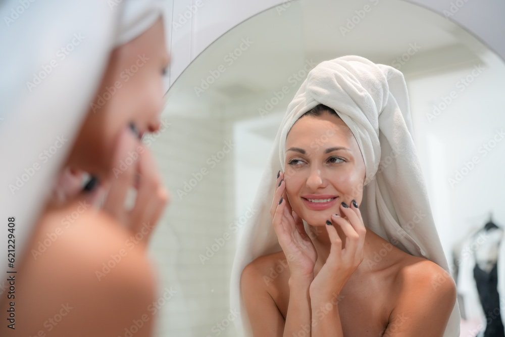 Skincare Concept. A Woman Looking In Mirror Touching Face And Perfect Skin At Bathroom. Selective Focus Skincare Concept. A Woman Looking In Mirror Touching Face And Perfect Skin At Bathroom. Selective Focus