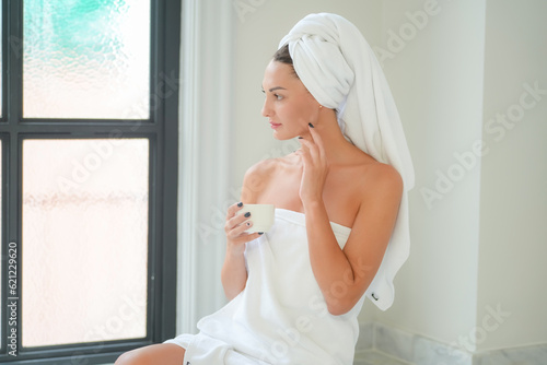 Daily Hygiene Concept. Beautiful Young Woman Drying Face With Towel In Bathroom, Happy Millennial Female Looking At Mirror, Enjoying Morning Beauty Routine At Home. Selective Focus On Reflection