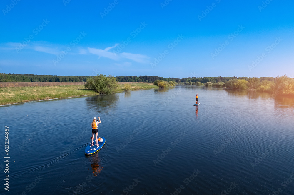Active fun, Woman floats on river on supboard, sun light. Concept summer lifestyle sport for fun