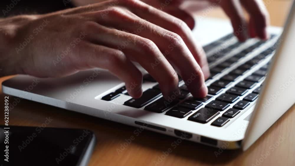 young man works typing on a laptop keyboard. Close-up young man works typing on a laptop keyboard. Close-up