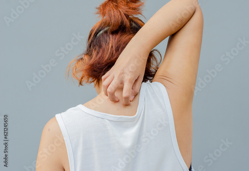 Quadro su tela young asian woman scratching itch with hand on upper back area, health care conc
