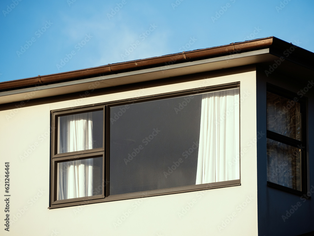 Window with three-panel awning frame under flat roof