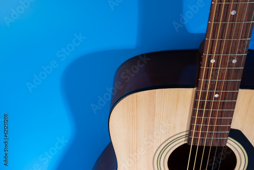 an acoustic guitar Close-up, classic instrument on the blue background, copy space