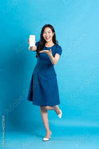 Portrait of beautiful woman in blue dress, isolated on blue background © 1112000