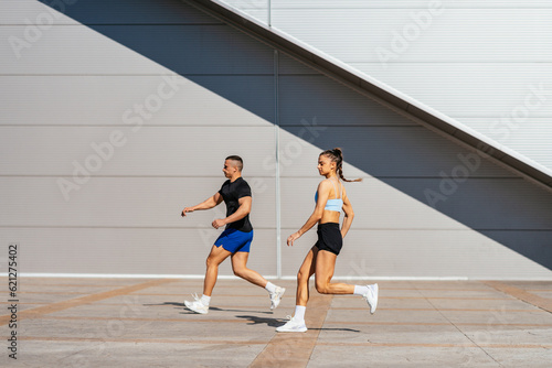 Two athletes running slowly outside