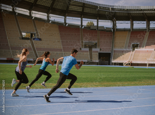 Three guys jogging on a blue sports track