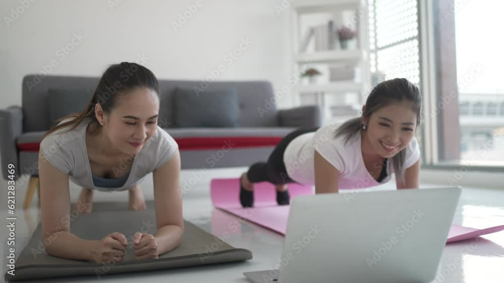 Women play yoga at home. Healthy lifestyle and friendship concept. Women play yoga at home. Healthy lifestyle and friendship concept.
