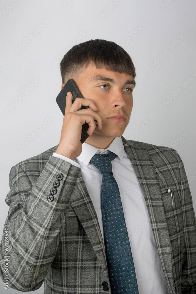 Young entrepreneur wearing a suit and tie making a phone call Young entrepreneur wearing a suit and tie making a phone call