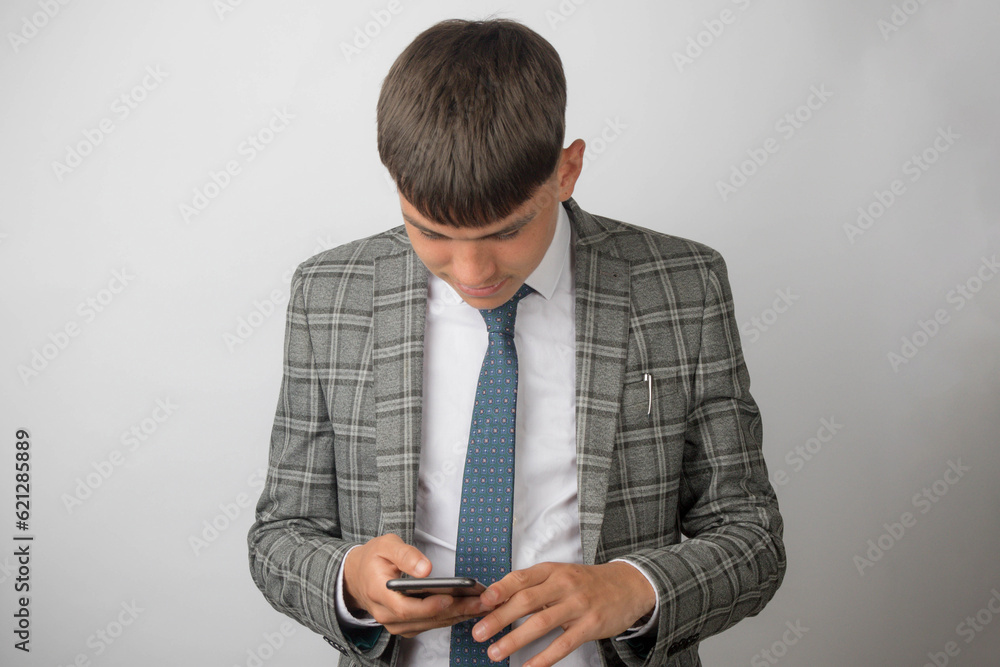 Young entrepreneur wearing a suit and tie typing on his phone Young entrepreneur wearing a suit and tie typing on his phone