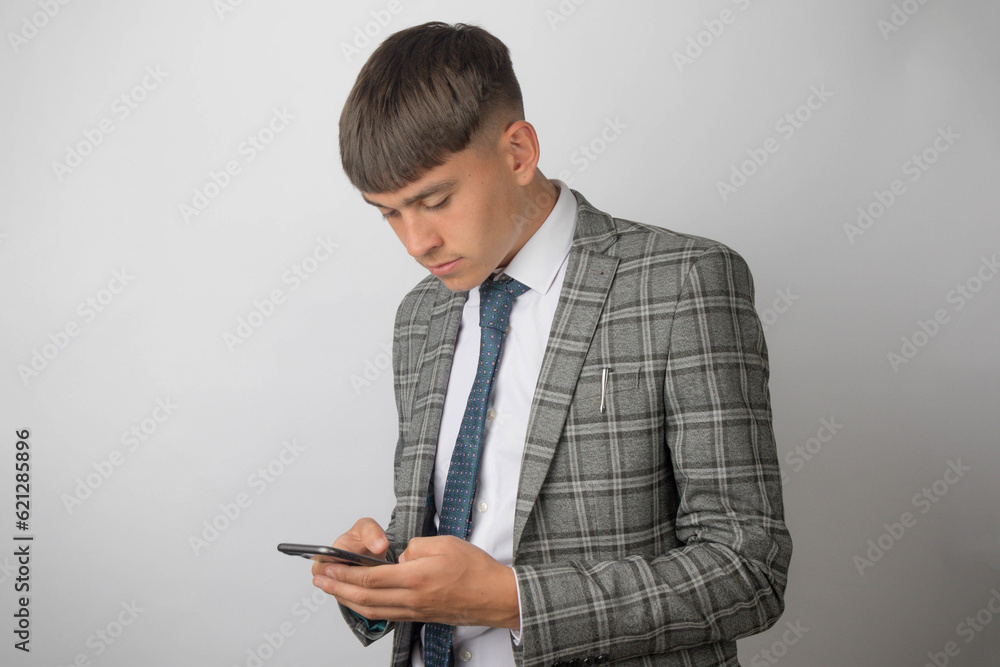 Young entrepreneur wearing a suit and tie typing on his phone Young entrepreneur wearing a suit and tie typing on his phone