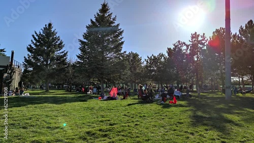 8K 7680x4320.Time lapse video of the public park.Happy people sunbathing on grass.Families with children on the lawn.Young girls playing.Spring sunny day crowded summer mixed green citypark relaxing. photo
