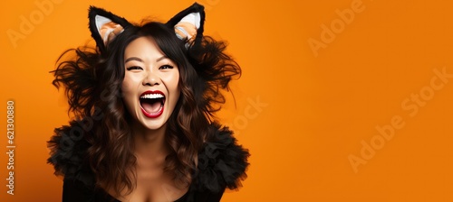 Fotografija Laughing Happy Adult Asian Woman Wearing a Cat Costume for Halloween on an Orang