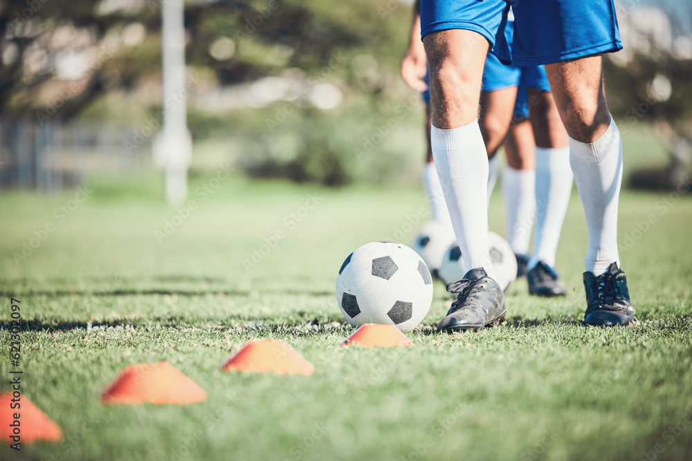 Obraz premium Feet, soccer player and ball with training cone on a field for sports game and fitness. Legs or shoes of male soccer or athlete person outdoor for agility, performance or workout on a grass pitch