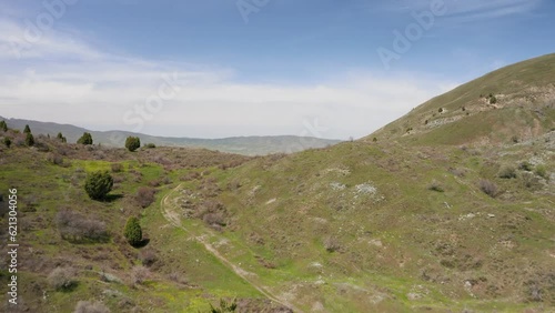 Span forward, offering views of a hilly valley in the mountains. Panoramic aerial view of hills and meadows in the foothills of the Tien Shan mountains