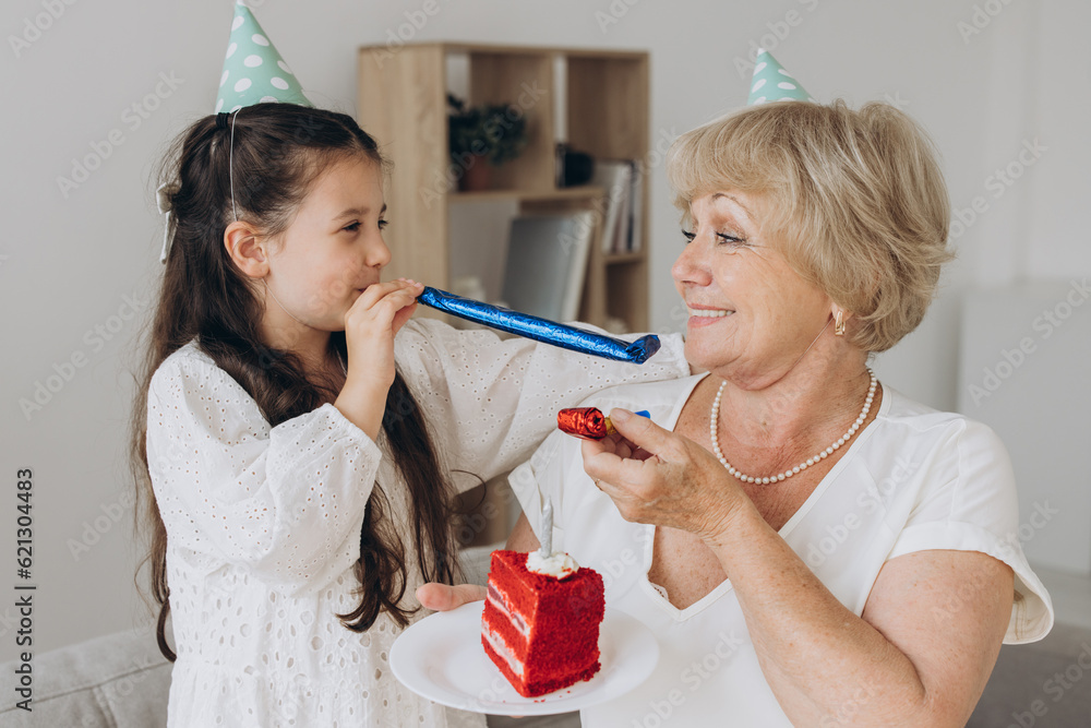 Happy smiling grandmother receives birthday greetings from granddaughter, little girl and senior