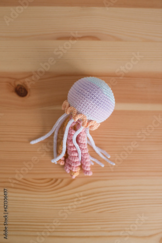 Handmade crocheted octopus on a wooden background. handmade.