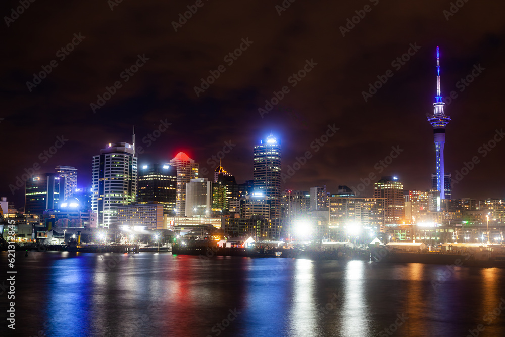 Night city of Auckland New Zealand. Glowing skyscrapers, bay and seaport of Auckland.